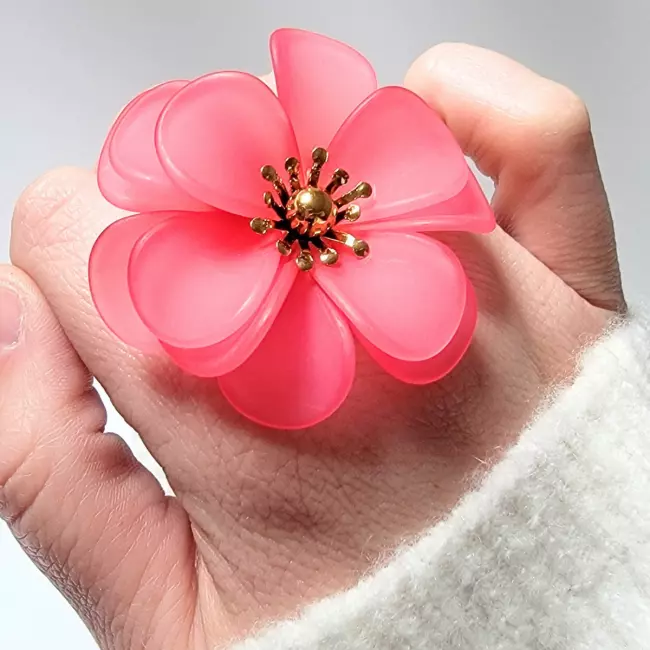 Bague fleur XXL ajustable en acier inoxydable doré avec une grande fleur en résine translucide de 4 cm, bijou fantaisie élégant et coloré.