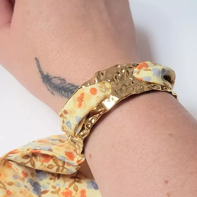 bracelet doré martelé et tissu fleuri noué au poignet
