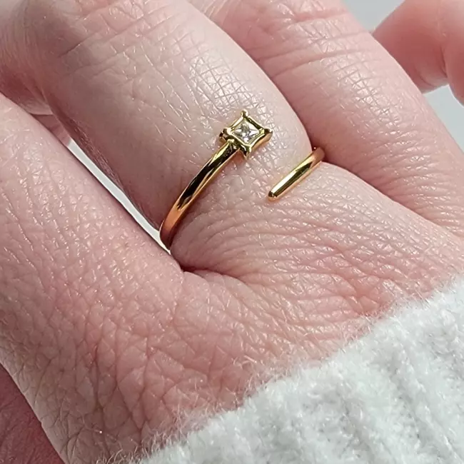 Bague dorée ajustable portée sur doigt, bijou féminin élégant et discret