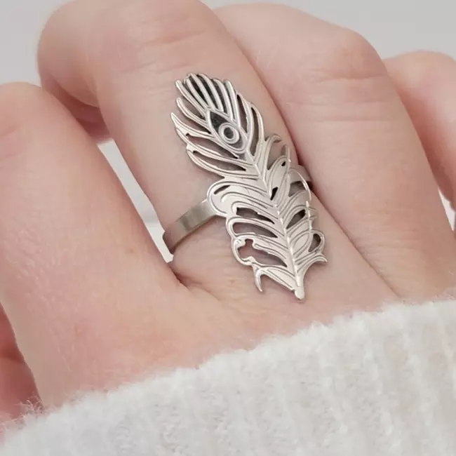Bague plume argentée portée sur une main féminine