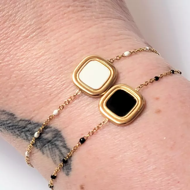 bracelets dorés portés au poignet, version noire et blanche côte à côte