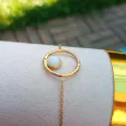 Bracelet ajustable doré et son pendentif rond évidé avec pierre blanche
