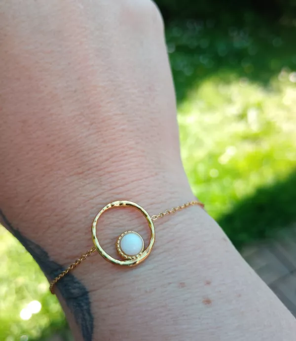 Bracelet ajustable doré et son pendentif rond évidé avec pierre blanche